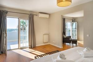a bedroom with a bed and a view of the ocean at Canaan Boutique Casa do Monte by Get Your Stay in Boliqueime