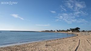 a beach with tracks in the sand and water at Issé IO - Maison à proximité de la plage in Dolus-d'Oléron +4 photos