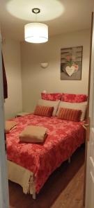 ein Schlafzimmer mit einem großen Bett mit roter Bettwäsche in der Unterkunft BERCK Maison de vacances avec terrasse et jardin, in Berck-sur-Mer