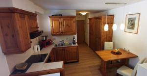 a kitchen with wooden cabinets and a wooden table at Gemütliches Apartment - Kanzelhöhe - Gerlitzen in Treffen