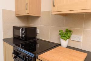 una cucina con forno a microonde e fornello forno superiore di Mulberry Cottage a Whithorn