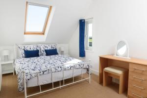 una camera da letto con un letto, una scrivania e uno specchio di Mulberry Cottage a Whithorn