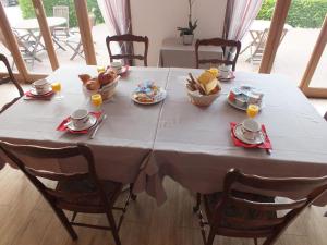 uma mesa branca com comida e bebidas em Hotel Restaurant Le Manguier em Peyrat-de-Bellac