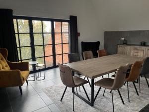 Un comedor con mesa y sillas de madera. en La Forteresse, en Borgloon