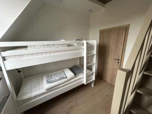 Litera con literas blancas en una habitación en La Forteresse, en Borgloon