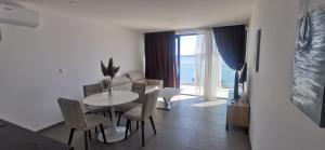 Un comedor con mesa y sillas y una sala de estar. en Apartmani Brela 15 luxury, en Brela