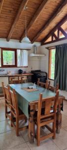 Una cocina con una mesa con sillas y una estufa. en Bosque Hermoso, en San Rafael