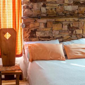 una cama en una habitación con una pared de piedra en Bosque Hermoso, en San Rafael