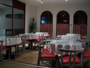 Santa Rosa de Viterbo的住宿－Hotel El Aerolito，一间设有白色桌子和红色椅子的餐厅