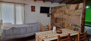 a living room with a couch and a stone wall at Bosque Hermoso in San Rafael