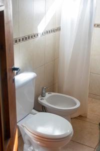 Un baño con un inodoro blanco y un lavabo. en Bosque Hermoso, en San Rafael