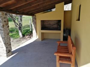 a porch with a bench and a wall with a fireplace at La Araucana in Tacuarembó