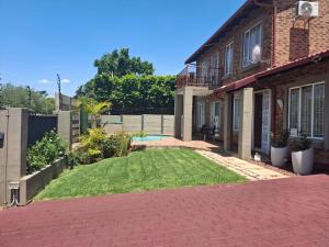 a backyard of a house with a yard of grass at Christa's Place 899 in Pretoria