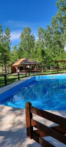 una piscina con banco y cenador en Bosque Hermoso, en San Rafael
