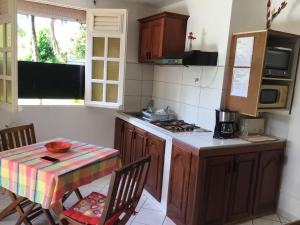 uma cozinha com uma mesa, uma mesa e um fogão em Philippe & Arlette SMITH em Sainte-Luce