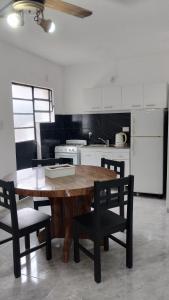 雷孔基斯塔Casona Apart2的厨房里有一张木桌和几把椅子