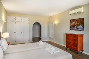 a bedroom with two beds and a dresser with towels at Canaan Boutique Casa do Monte by Get Your Stay in Boliqueime