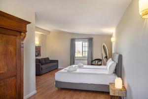 a bedroom with a large bed and a couch at Canaan Boutique Casa do Monte by Get Your Stay in Boliqueime