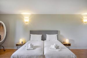 a bedroom with a large white bed with two pillows at Canaan Boutique Casa do Monte by Get Your Stay in Boliqueime