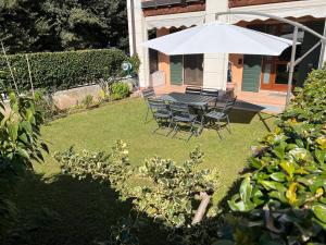 a table and chairs under an umbrella in a yard at Sweet Home Apartment in Cavaion Veronese +29 photos