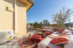 un patio con sofás y almohadas en un balcón en Casa Madera with lovely terrace, en Milán