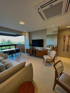 a living room with a couch and a table and a television at Flat Colina - Eco Resort Praia dos Carneiros in Tamandaré