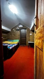 KanthalloorにあるAlpine Mud house Kanthalloorのベッド2台とドアが備わる部屋