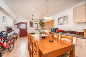 a kitchen and living room with a wooden table and a dining room at Casa da Praia 2 in Budens