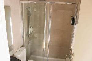 a shower with a glass door next to a toilet at 9min Metro to Downtown - couples&kids - free parking in Porto +12 photos