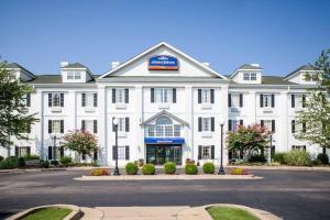 a white building with a sign on the front of it at Howard Johnson by Wyndham Jackson in Jackson