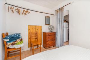 a bedroom with a bed and a chair and a dresser at Casa da Praia 2 in Budens