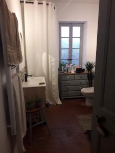 a bathroom with a sink and a toilet and a window at Maison Rose - Maison de village avec jardin privé, centre Capestang in Capestang