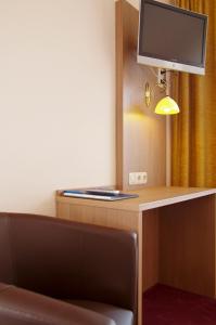 Zimmer mit einem Schreibtisch, einem TV und einem Stuhl in der Unterkunft Gasthof & Landhotel Ohrnbachtal in Weilbach
