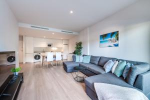 a living room with a blue couch and a kitchen at Estepona luxury apartments in Estepona