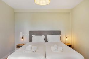 a bedroom with a large white bed with two white towels at Canaan Boutique Casa do Monte by Get Your Stay in Boliqueime