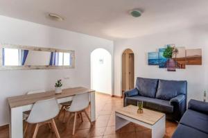 a living room with a blue couch and a table at Cabo de Gata - Apartamento al lado de la playa in La Isleta del Moro