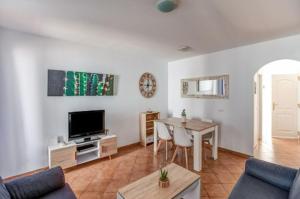 a living room with a table and a television at Cabo de Gata - Apartamento al lado de la playa in La Isleta del Moro