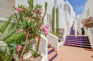 a street with white buildings and pink flowers at Cabo de Gata - Apartamento al lado de la playa in La Isleta del Moro