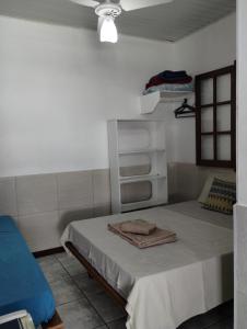 a small room with a bed with a white at Canto da Arte - Hospedagem Domiciliar in Cabo Frio +17 photos