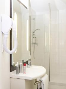 a white bathroom with a sink and a shower at ibis Chambery in Chambéry