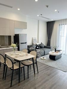 a kitchen and a living room with a table and chairs at Bunnys Homes - Service Apartment in Gia Lâm Pho