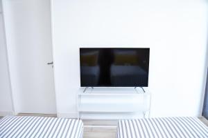 布宜诺斯艾利斯Up Recoleta Apartments的一间带电视和两张床的客厅