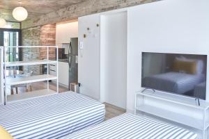 布宜诺斯艾利斯Up Recoleta Apartments的客厅配有两张床和一台平板电视