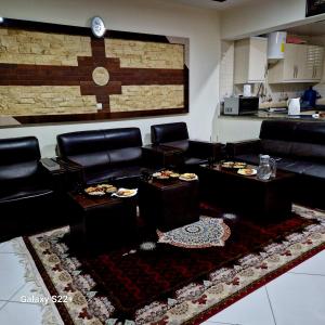 a living room with black leather furniture and a rug at Luxury Living in Kabul in Kabul