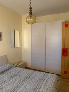 1 dormitorio con 1 cama y armario grande en Appartamento centrale Sappada, en Sappada 1 foto más