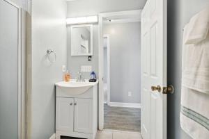 Un baño blanco con lavabo y espejo. en The Beach Bum, en Ponte Vedra Beach
