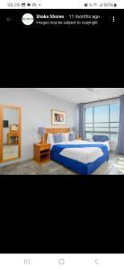 a bedroom with a large bed and a window at Shaka Shores in Durban