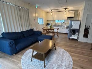 a living room with a blue couch and a table at ライフタイムハウス55 in Furugen