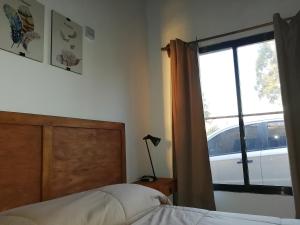 a bedroom with a bed and a window with a car outside at La Araucana in Tacuarembó