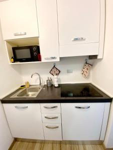 a kitchen with white cabinets and a sink at "Suite Sesto" Metro M1 to Milano, Rho Fiera, Monza in Sesto San Giovanni